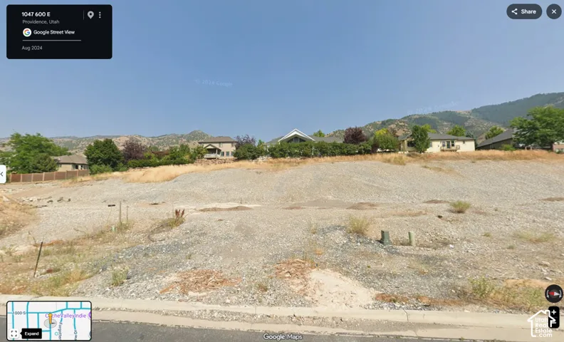 Vacant residential lot featuring a sloping topography and prominent mountain backdrop