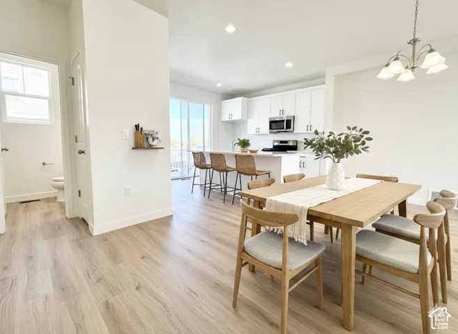 Kitchen featuring white cabinetry, wood-finish flooring, a central island, recessed lighting, and a sliding glass door