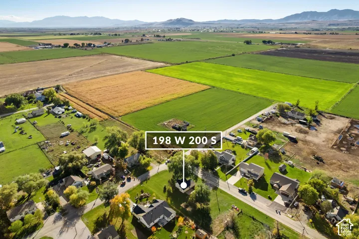 Aerial perspective showcasing a residential lot featuring mature trees and expansive mountain backdrops