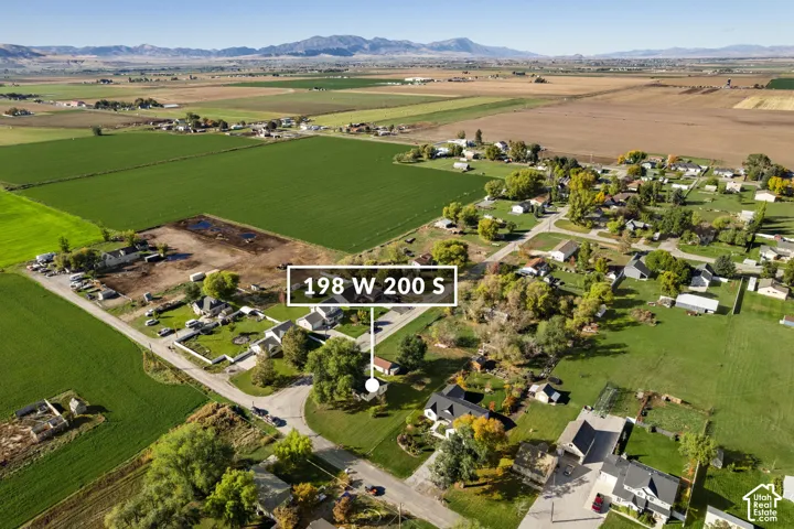 Aerial perspective featuring a residential lot with mature trees and expansive mountain backdrops