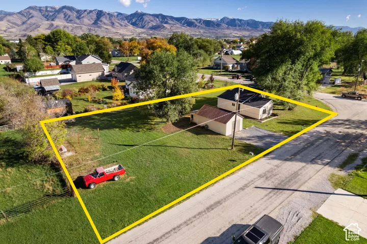 Expansive corner lot featuring mature trees, a detached garage, and prominent mountain backdrop