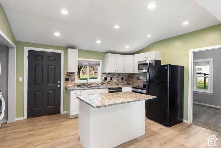 Kitchen featuring a center island, stone-finish countertops, mosaic tile backsplash, recessed lighting, and wood-finish flooring
