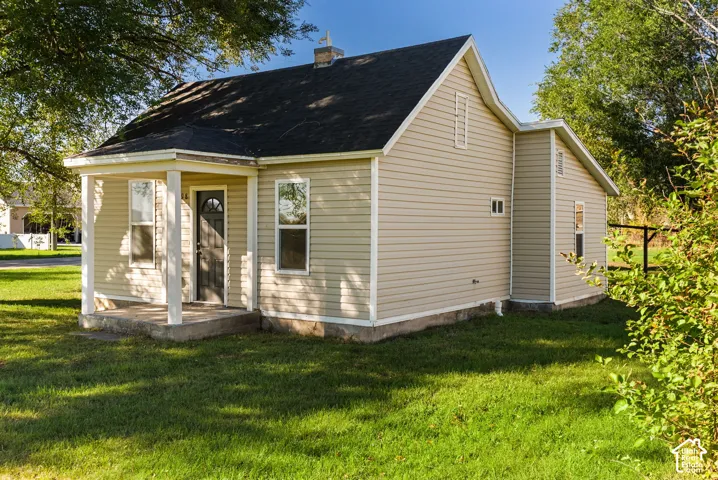 Single-story residence featuring light-toned vinyl siding, an asphalt shingle roof, a covered front porch with square columns, and a concrete foundation