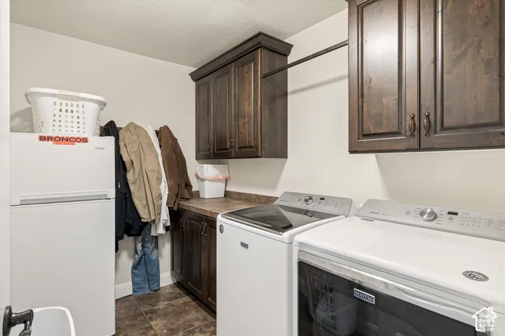 Utility room featuring dark-stained wood cabinetry, stone-finish countertops, tiled flooring, and a wall-mounted garment rod
