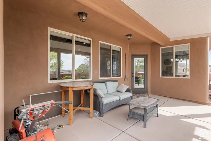 Covered patio featuring a concrete floor, smooth stucco exterior walls, inset ceiling lighting, and multiple sliding windows