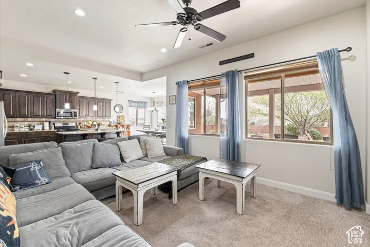 Living area featuring recessed lighting, a ceiling fan, and large windows with horizontal blinds