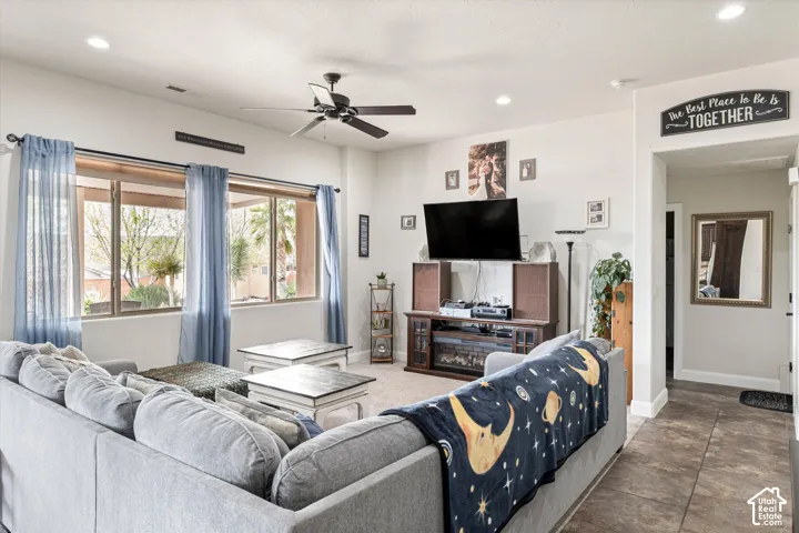 Living area featuring recessed lighting, a ceiling fan, large windows, and tile flooring