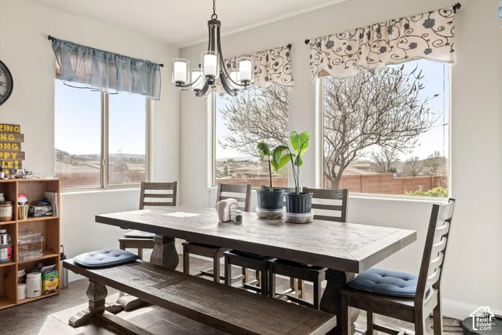 Dining area featuring large windows with natural lighting, tile flooring, and a multi-light chandelier