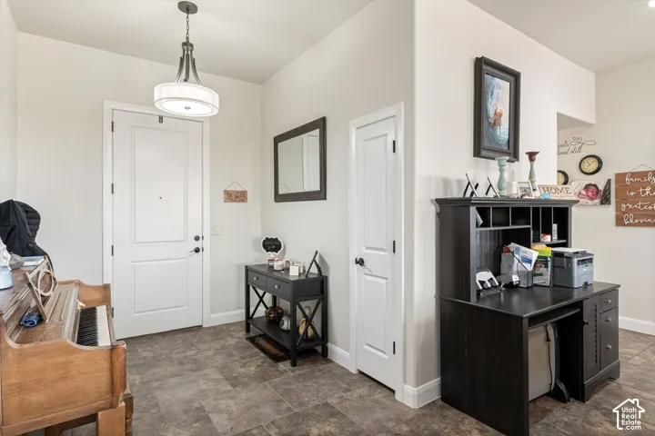 Entryway featuring tile flooring, a multi-panel door with matte black hardware, and a tiered drum pendant light fixture