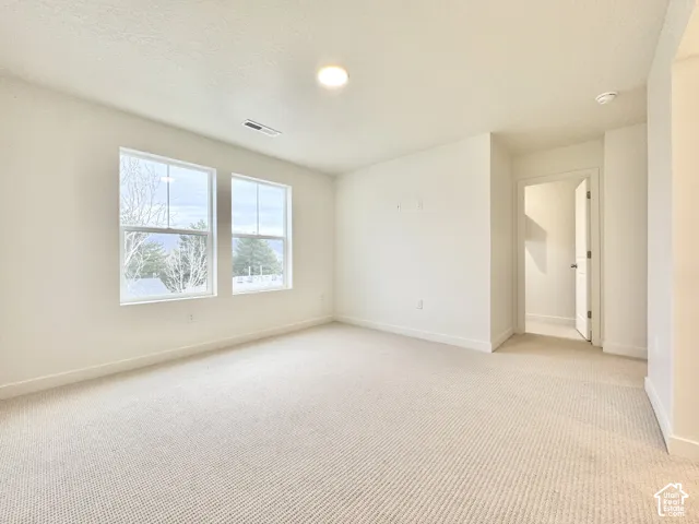 Neutral-toned wall-to-wall carpeting, dual paned windows, and recessed ceiling lighting