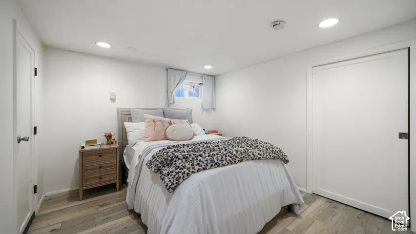 Bedroom featuring wood-finish flooring, recessed lighting, and a built-in closet with shaker-style door