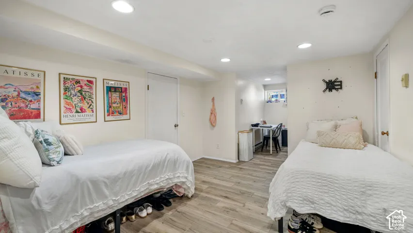 Neutral-toned room featuring wood-finish flooring, recessed lighting, and a window
