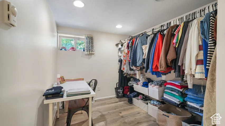 Storage area featuring wood-finish flooring, recessed lighting, and a window