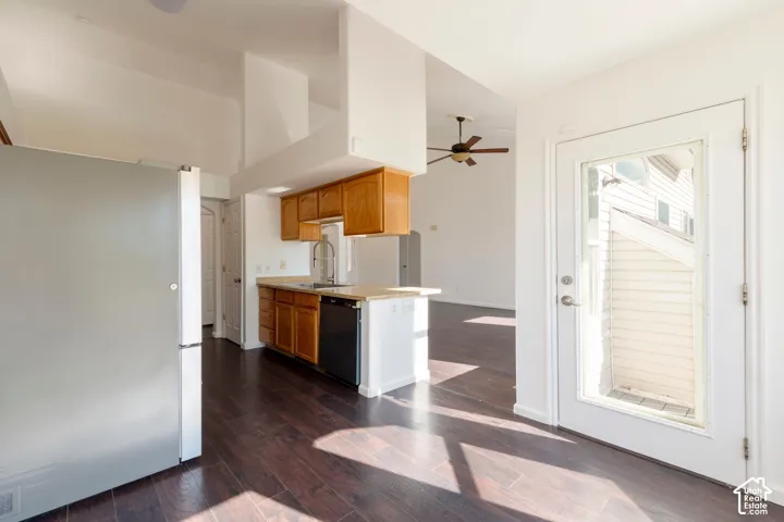 Kitchen area featuring wood-finish cabinetry, stone-texture countertops, wood-finish flooring, and a glass-panel exterior door