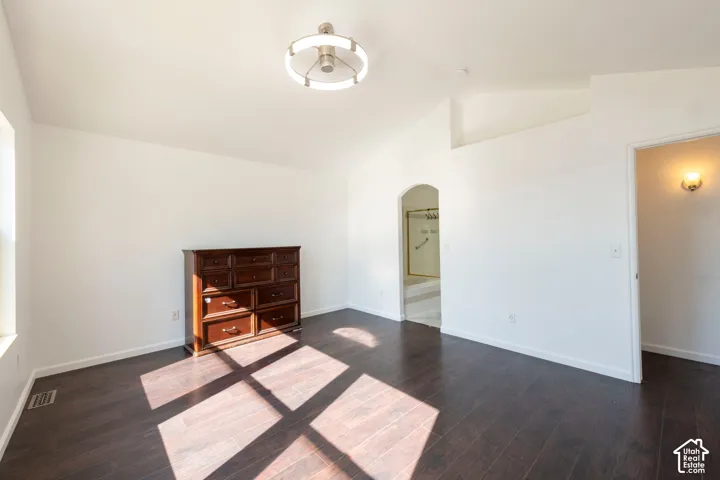 Vaulted ceilings, wood-finish flooring, and a modern circular chandelier