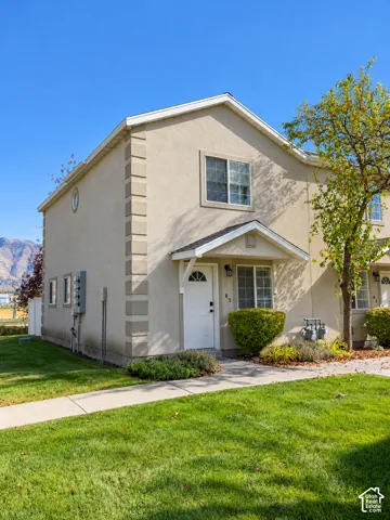 Stucco exterior featuring decorative corner quoins, a front-facing gable roofline, and a mountain backdrop