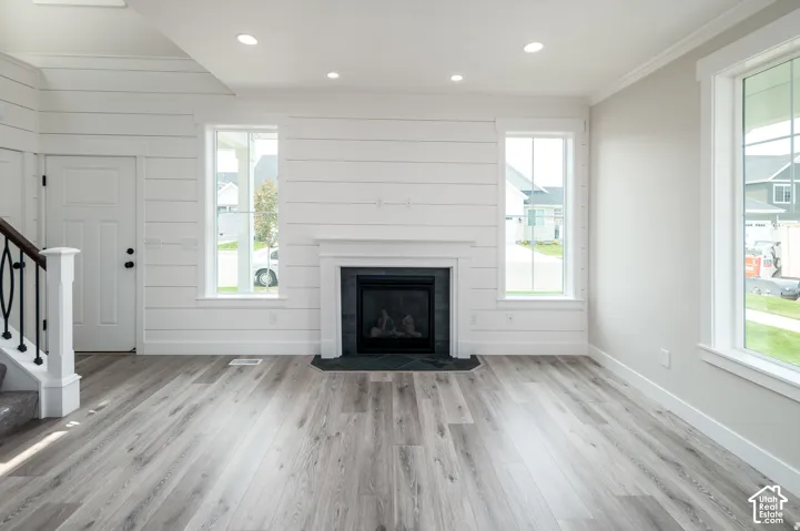Living area featuring a fireplace with a dark tile surround and white mantel, wood-finish flooring, recessed lighting, and multiple windows