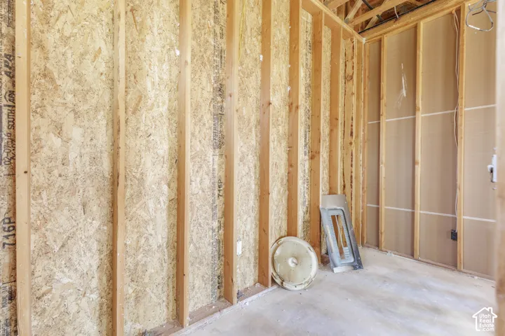 Exposed timber framing, oriented strand board (OSB) wall sheathing, unfinished concrete flooring, and electrical rough-in installation