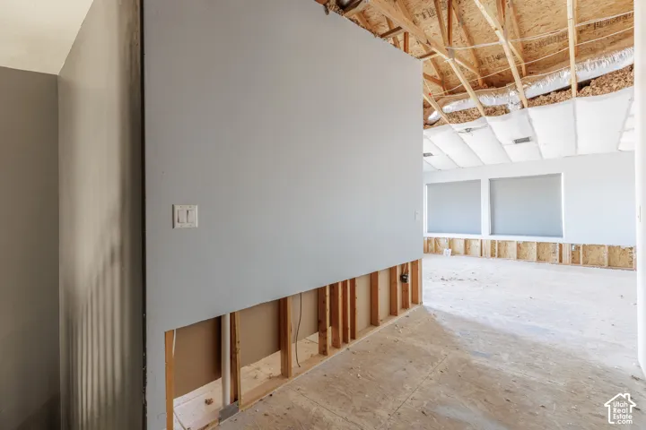 Interior space featuring exposed wood framing, high-angle rafter construction, and large window openings