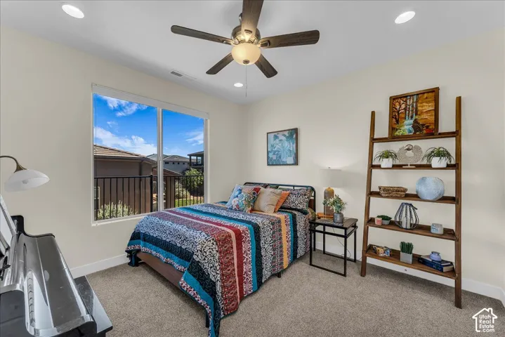 Room featuring large windows with exterior metal railing, neutral carpeting, recessed lighting, and a ceiling fan with integrated light fixture