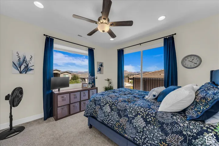 Room featuring neutral carpeting, a ceiling fan with integrated lighting, recessed lighting, large windows, and a sliding glass door