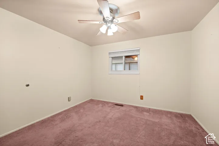 Room featuring carpeted flooring, a ceiling fan with integrated lighting, and a window with horizontal blinds