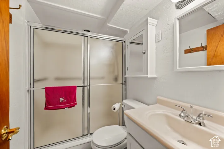 Full bathroom featuring a walk-in shower with sliding glass doors, built-in medicine cabinet, integrated sink vanity, and framed wall mirror