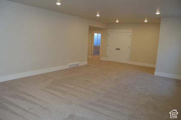 Open interior space featuring recessed ceiling lighting, wall-to-wall carpeting, and double doors with matte black hardware