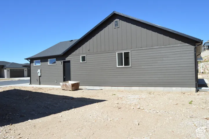Exterior features include dark horizontal and vertical siding, a gabled roofline, and rectangular white-framed windows