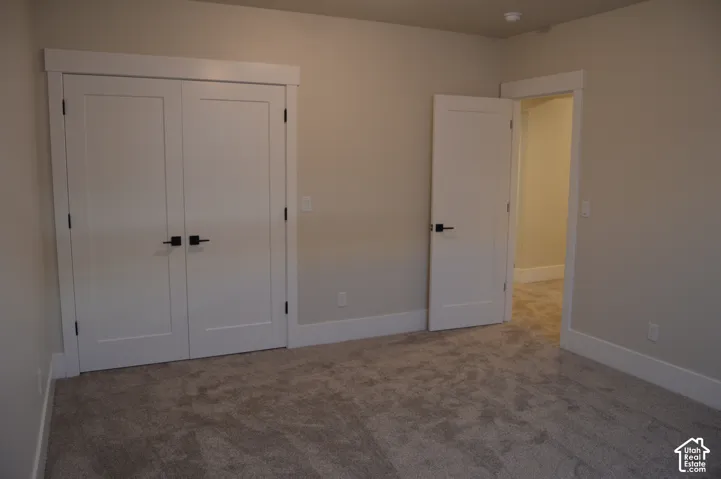 Neutral wall tones with carpeted flooring, white shaker-style interior doors, and matte black hardware
