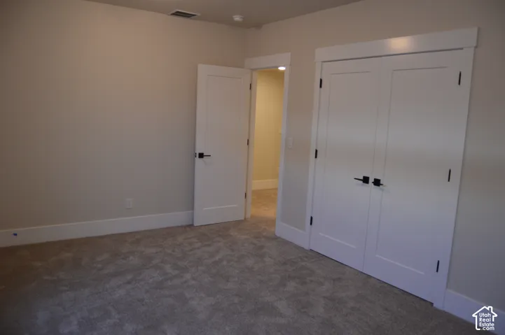 Neutral-toned interior featuring textured carpeting, white shaker-style doors, and matte black hardware