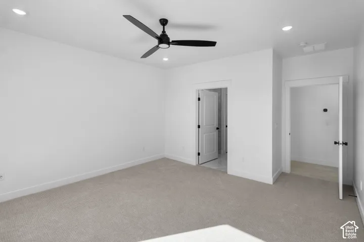 Neutral-toned wall-to-wall carpeting, matte black finish ceiling fan, recessed lighting, and solid-core interior doors with matte black hardware