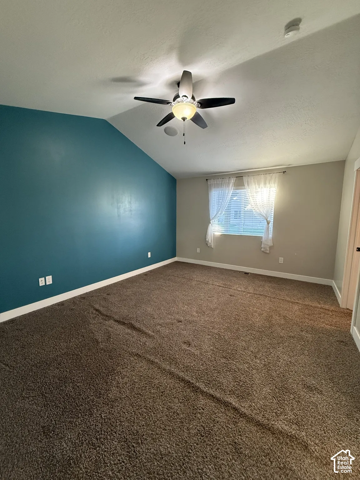 Vaulted ceiling, accent wall, and ceiling fan with integrated light fixture
