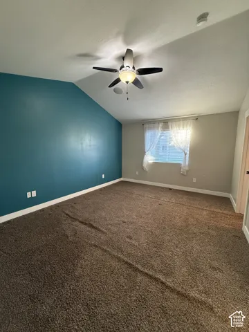 Vaulted ceiling, accent wall, and ceiling fan with integrated light fixture
