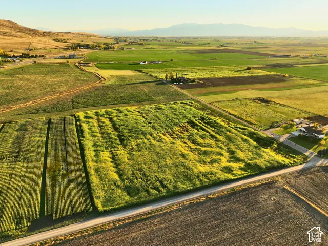 Expansive acreage looking South featuring cultivated fields, and prominent mountain backdrops