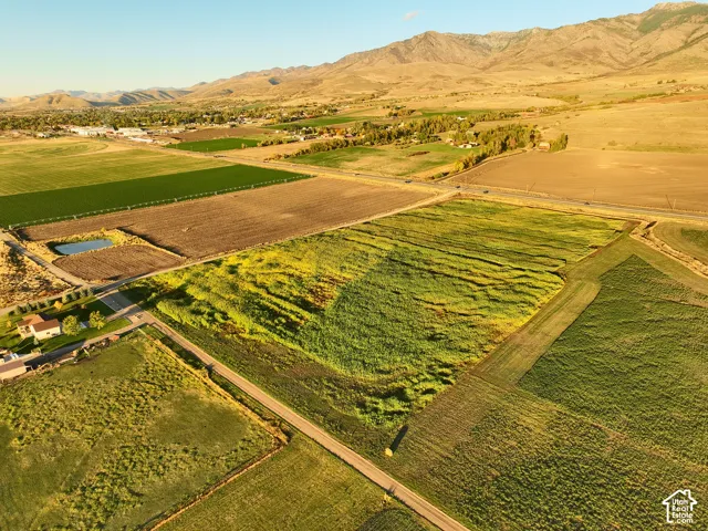 Expansive acreage looking North East featuring open fields, and prominent mountain backdrops