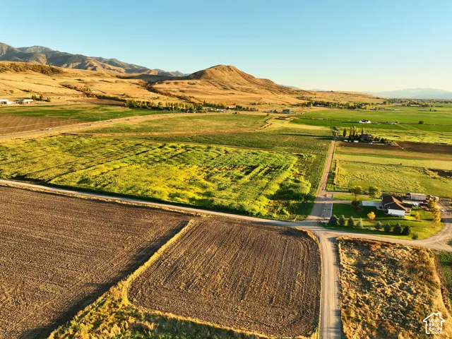 Expansive acreage looking South East featuring cultivated fields, open terrain, and a mountainous backdrop