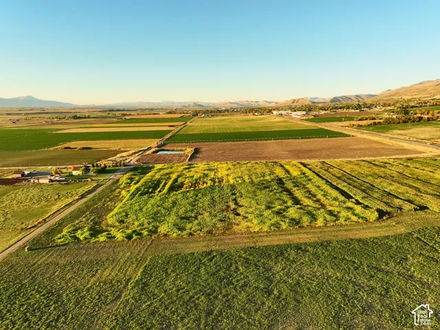 Expansive acreage looking North featuring vast cultivated fields, open terrain, and a mountain range backdrop