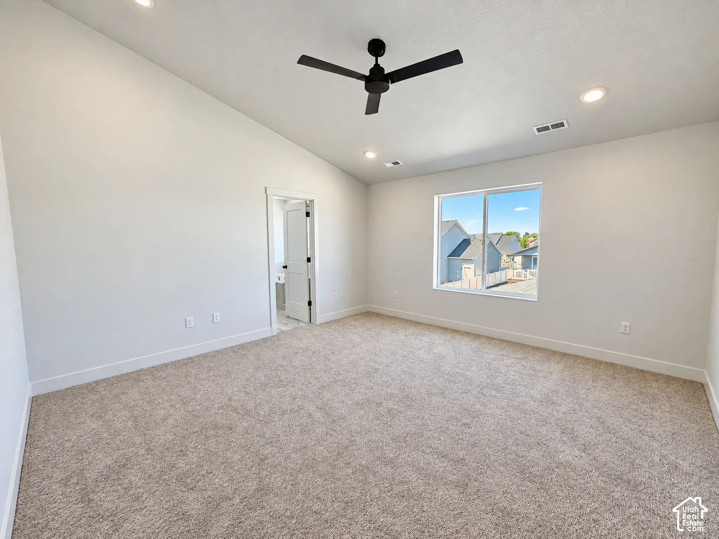 Vaulted ceilings featuring recessed lighting, a matte black ceiling fan, neutral wall-to-wall carpeting, and a large window