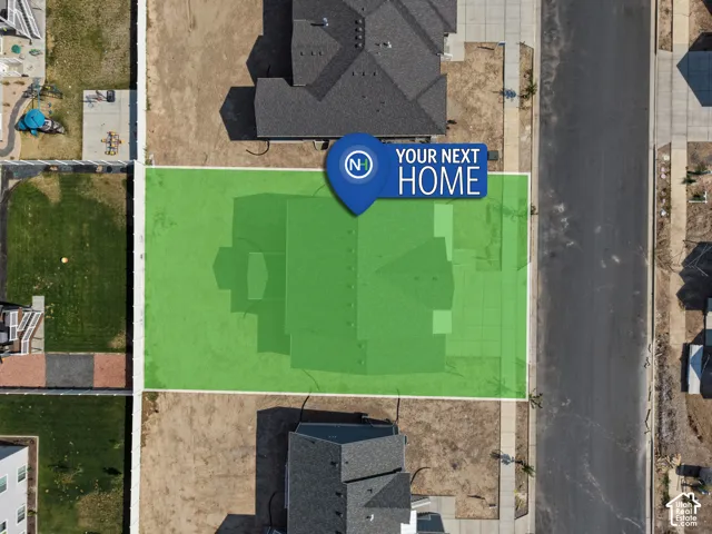 Aerial perspective of a residential lot featuring paved street access, concrete sidewalk, and designated property boundaries
