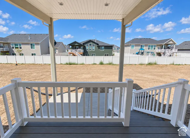 Covered patio featuring composite decking, white vinyl railings, recessed lighting, and a concrete landing