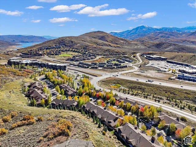 Aerial perspective featuring mountainous terrain, rolling topography, and deciduous vegetation with established infrastructure and multi-unit residential structures