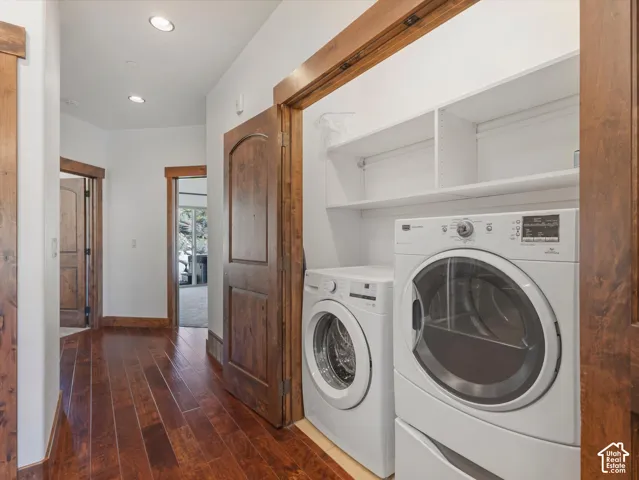 Laundry alcove featuring built-in white shelving, recessed lighting, and stained wood door trim with matching solid-core doors over wood-finish flooring