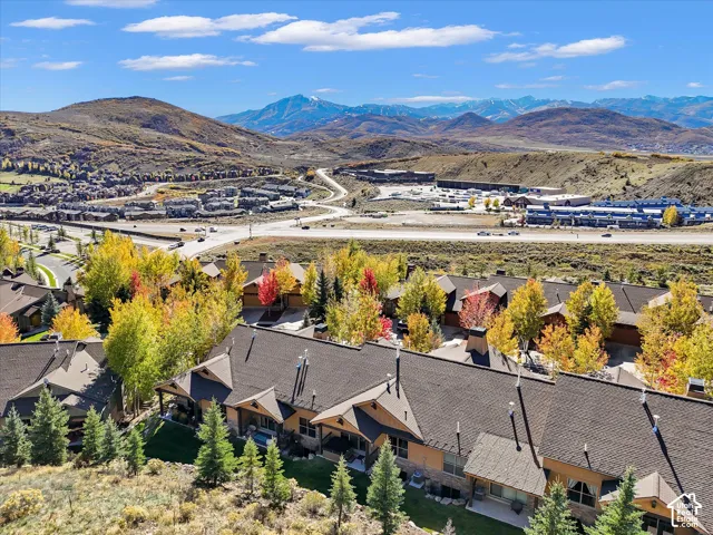 Multi-unit exterior featuring mountain scenery, tiered rooflines, masonry accents, and expansive wooded landscaping