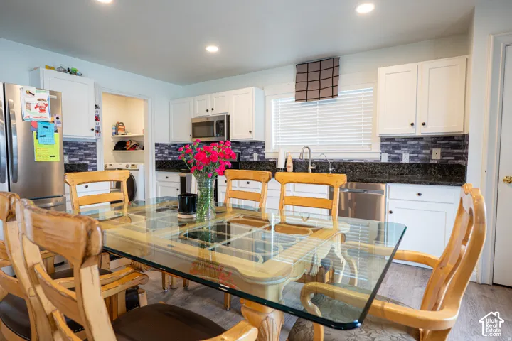 Kitchen featuring white shaker-style cabinetry, dark stone countertops, decorative tile backsplash, recessed lighting, and stainless steel appliances