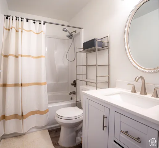 Bathroom featuring a white vanity cabinet with a stone-composite countertop, undermount sink, brushed nickel widespread faucet, and an oval wall mirror with a beaded frame