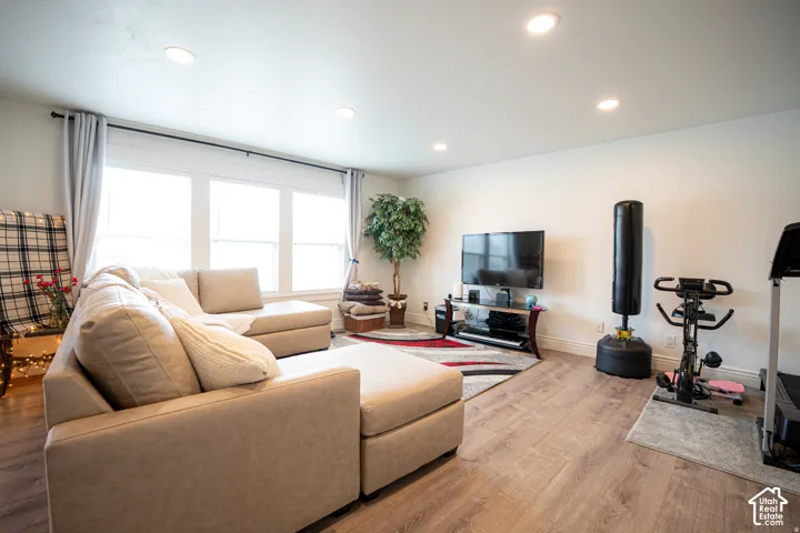 Living area featuring wood-finish flooring, recessed lighting, and large windows with multi-pane glass