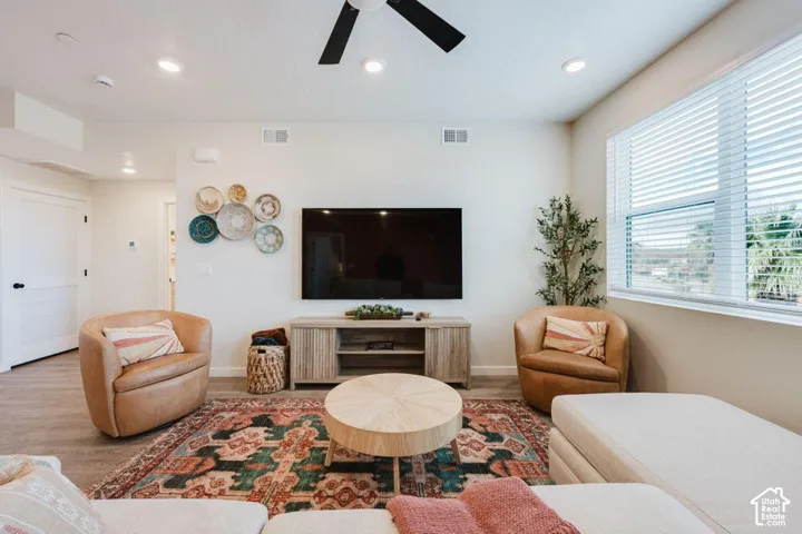 Interior space featuring recessed lighting, a ceiling fan, large windows with horizontal blinds, and wood-finish flooring
