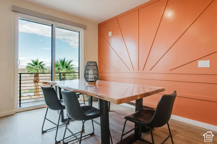 Accent wall with custom wood paneling, sliding glass door, and wood-finish flooring
