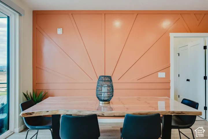 Accent wall featuring geometric millwork molding, glass sliding door, and neutral wood-finish flooring